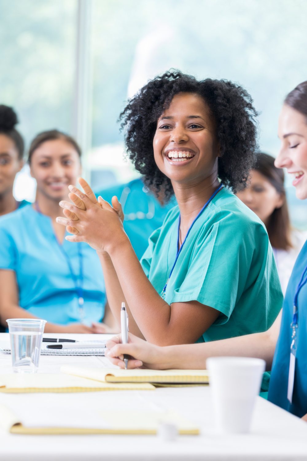 Beautiful African American nurse enjoys attending healthcare seminar African American healthcare worker smiles as she listens to the speaker during a seminar