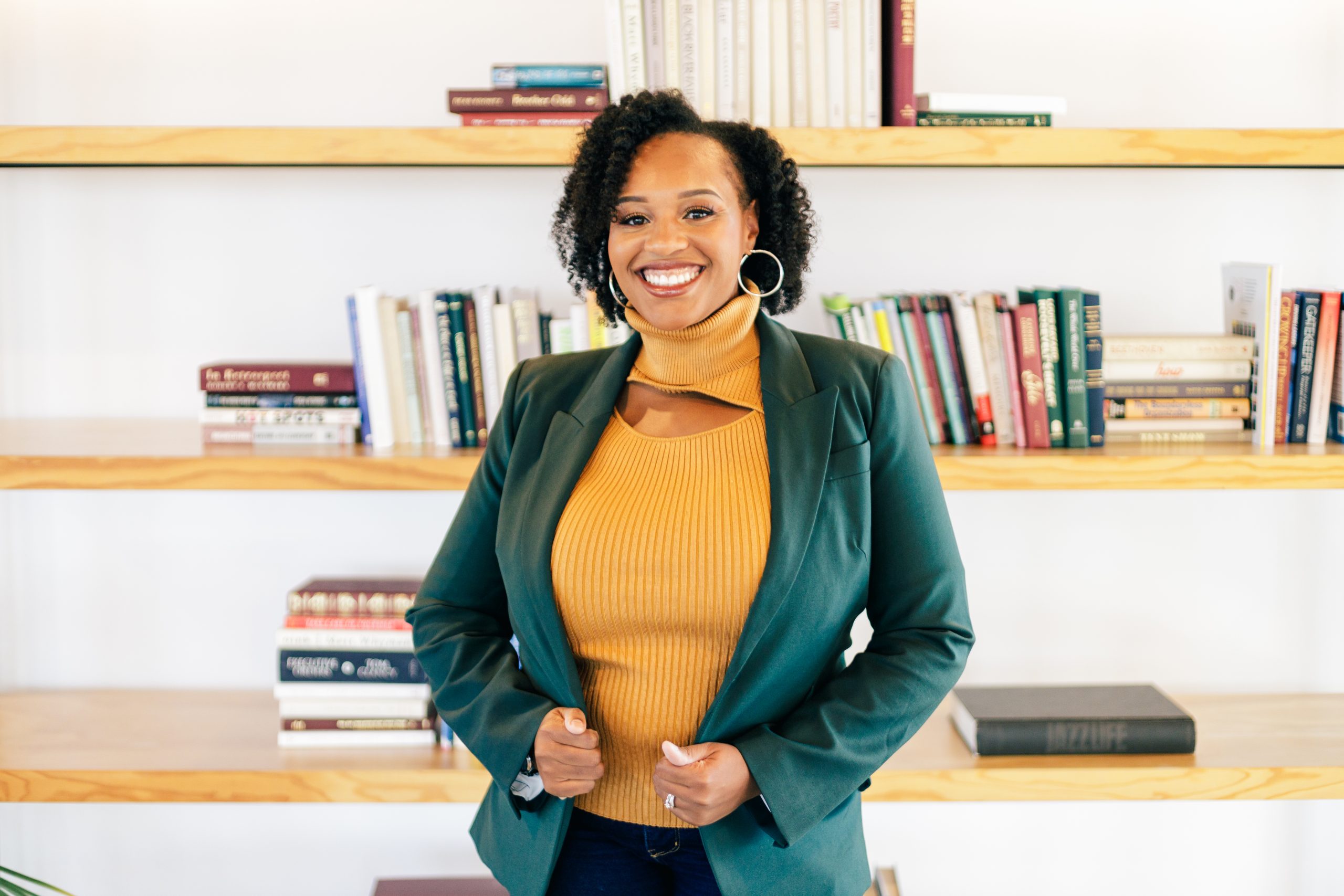 Meet Dr. Gabrielle Jones - Smiling in front of bookshelf